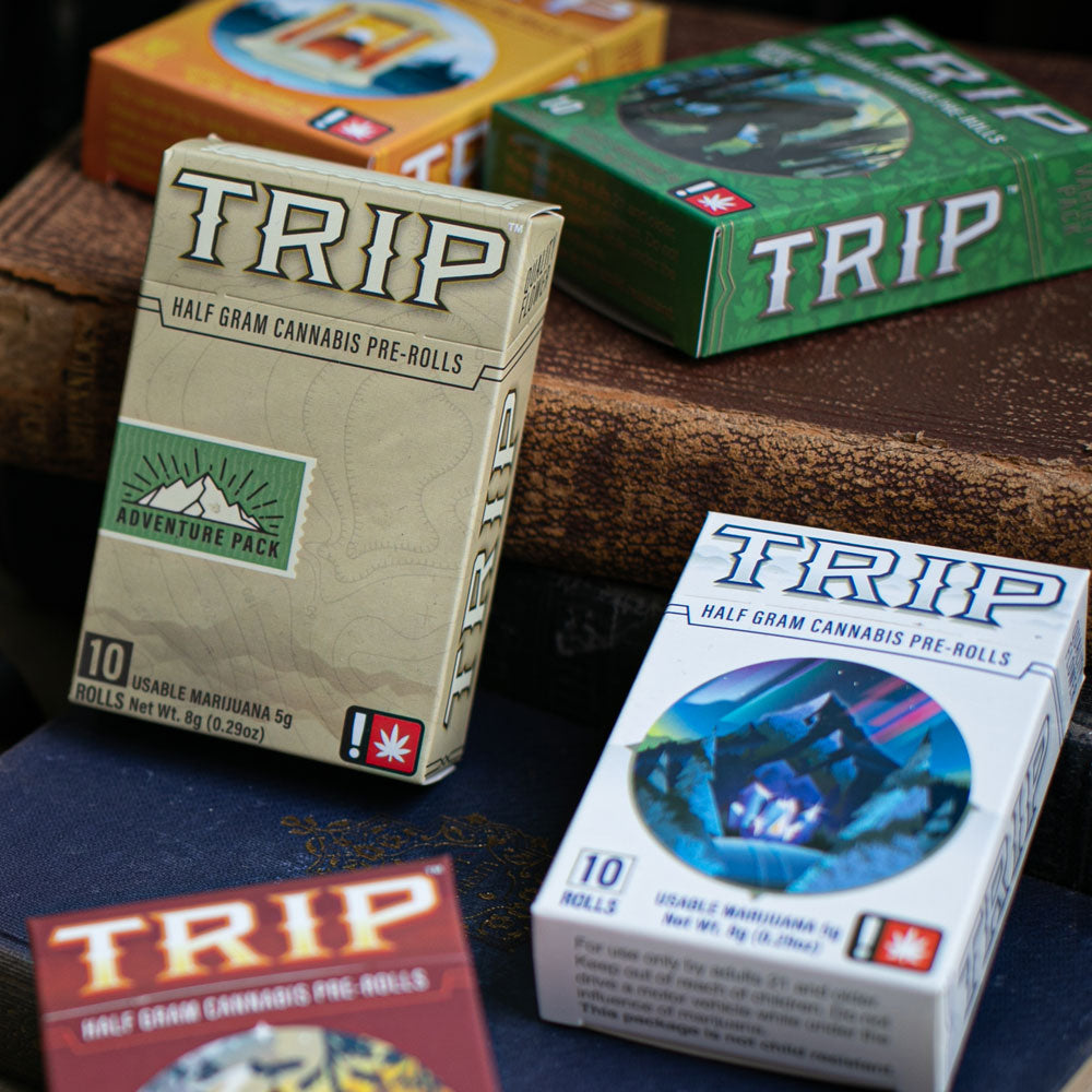 Trip Pre-Roll Boxes laying against an old book